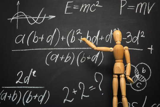 Maths formulas on a blackboard and wooden man