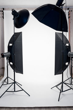 Photo studio equipment and white paper background indoors, no people