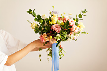 Florist hand with beautiful flowers bouquet
