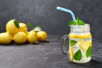 Freshly made lemonade in jars on a black background,  cold refreshing drink . Healthy and detox water drink.