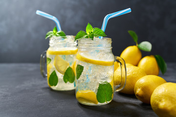 Two jars of cold lemonade on a black background