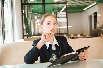 baby girl in costume sitting at a table. business girl