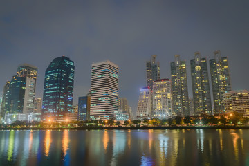 Plakat Night city at the park with commercial building.