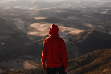 Man with red sweatshirt with blurred landscape