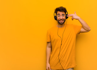 Young man listening to music doing a suicide gesture