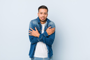 Fototapeta premium Young handsome filipino man going cold due to low temperature or a sickness.