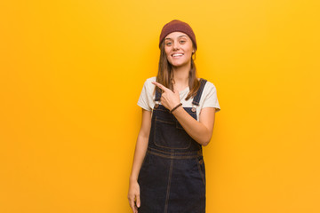 Young hipster woman smiling and pointing to the side