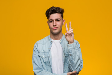 Young handsome student wearing a denim shirt showing number two with fingers.