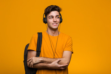 Fototapeta na wymiar Young cool student man listening to music with headphones biting fingernails, nervous and very anxious.