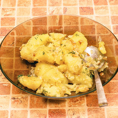 Potatoes with a spoon in a plate on table