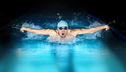 Man in swimming pool. Butterfly style