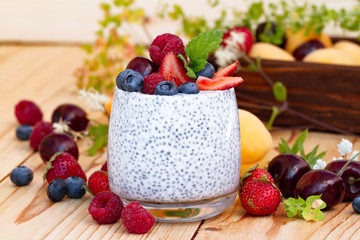 Chia seed pudding with berries on wooden table. rustic stile healthy Breakfast. Chia seed with milk, fruits and fresh berry. well being weight loss concept. yogurt drink, vitamin cocktail.