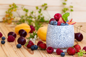 Chia seed pudding with berries on wooden table. rustic stile healthy Breakfast. Chia seed with milk, fruits and fresh berry. well being weight loss concept. yogurt drink, vitamin cocktail.