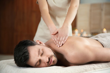 Fototapeta na wymiar Handsome man receiving back massage in spa salon