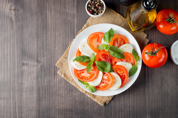 Close-up photo of caprese salad with ripe tomatoes, basil, buffalo mozzarella cheese. Italian and Mediterranean food concept. Fresh and healthy organic meal. Starter and antipasti.