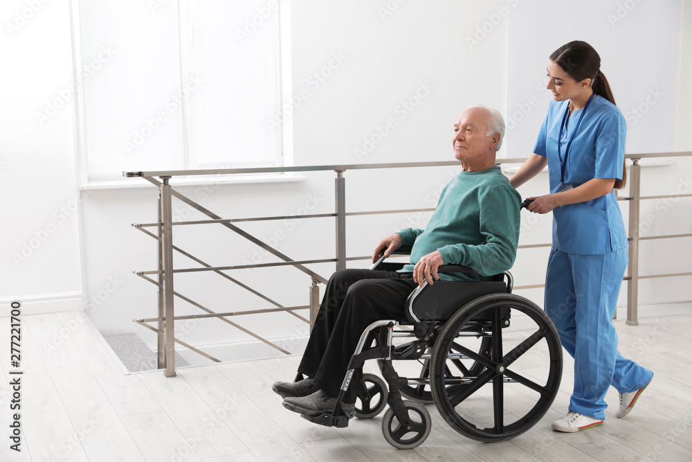 Canvas Prints Nurse assisting senior man in wheelchair at hospital