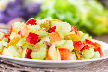 Fresh Waldorf salad made of celery, apple, walnuts, sultanas and raisins on plate (Selective Focus, Focus in the middle of the image)