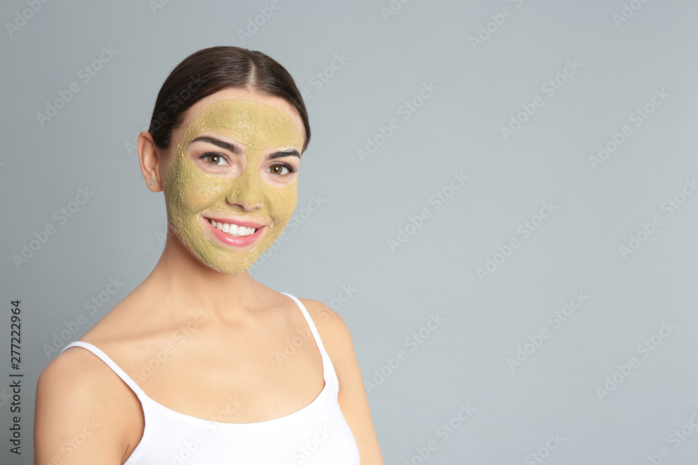 Poster Young woman with clay mask on her face against grey background, space for text. Skin care