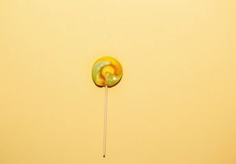 Red, yellow color lollipops on yellow paper background. Concept of hollyday card
