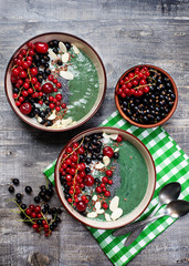 Healthy organic smoothie with spirulina and banana, decorated with berries, seeds and coconut flakes. Fashionable and healthy food from natural ingredients. Super food