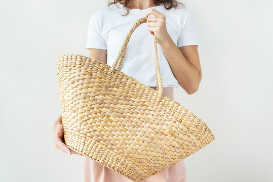Woman is holding fashionable accessory straw bag