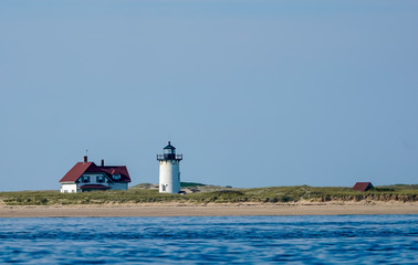 lighthouse on coast of sea with keeper's house