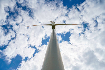 turning wind turbine and cloudy sky