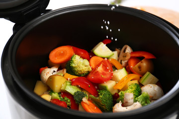 Adding salt to vegetables in multi cooker, closeup