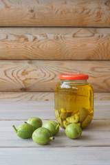 green walnut in a glass jar filled with alcohol, tincture for treatment.