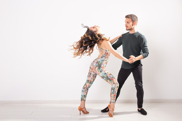Social dance, kizomba, tango, salsa, people concept - beautiful couple dancing bachata on white...
