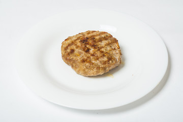 Meat roast cutlet on a white plate on a white background.
