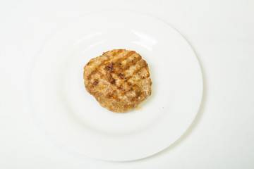 Meat roast cutlet on a white plate on a white background.