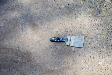Hand trowel on asphalt background. Building tools. The concept of repair.