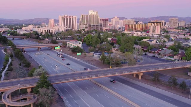 Aerial: Reno city skyline and freeway traffic at sunset
