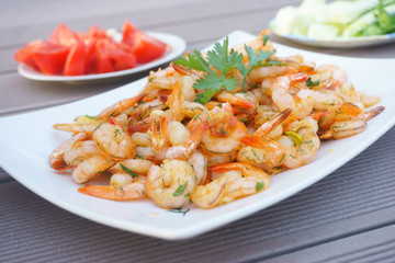 fried shrimps on a white plate with herbs 