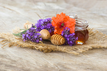 honey and flowers on wooden  background