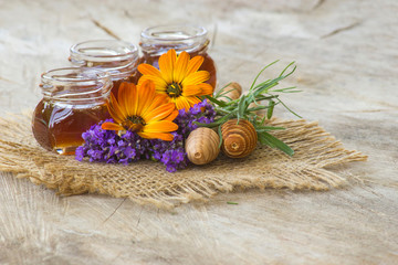 honey and flowers on wooden  background