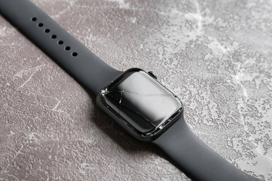 Broken smart watch on marble background, closeup. Repair service