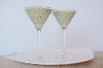Smoothies green on the table in two glasses