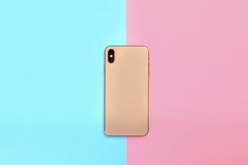 Modern smartphone on colorful background, top view