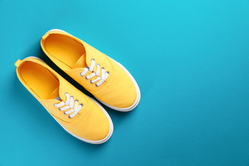 Pair of bright sneakers on colorful background, top view. Space for text