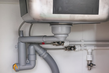 Water trap and water drain under the kitchen sink.