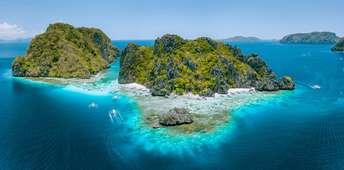Aerial drone view of tropical Shimizu Island steep rocks and white sand beach in blue water El Nido, Palawan, Philippines. Tourist attraction most beautiful famous nature spot Marine Reserve Park