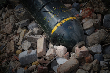 Unexploded bomb in rubble, large green metal missile