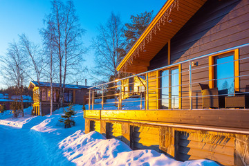 Cottage with veranda on sunny winter day. Winter villa near the forest. Karelian holiday resort....