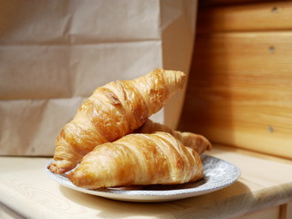 Freshly baked croissants on a small white plate