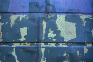 Metal surface with peeling blue paint and rust