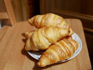 Freshly baked croissants on a small white plate