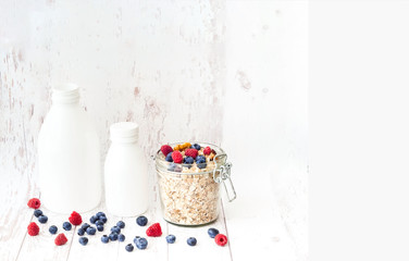 Obraz na płótnie Canvas Muesli with blueberries in glass jar on white wooden background.
