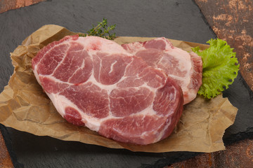Raw pork steak over wooden board